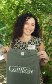 Francesca Varela holding a Compose Creative Writing Conference t-shirt.