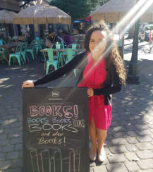 Francesca Varela standing next to a books sign outside.